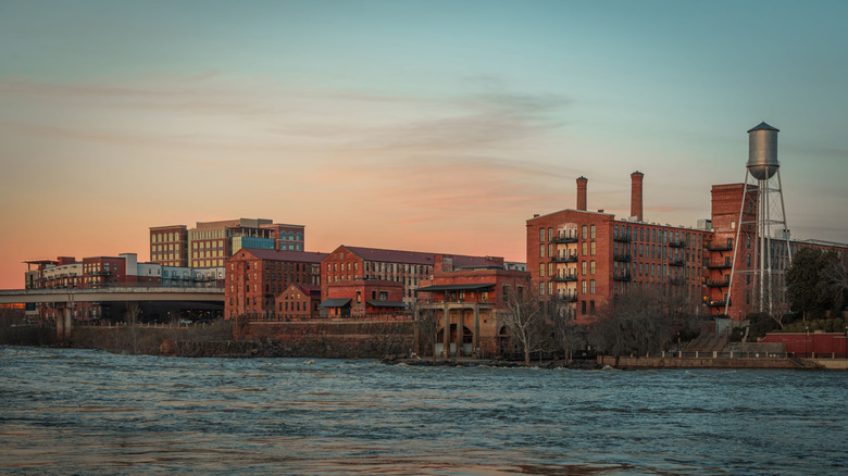 The Chattahoochee River bank and several buildings during sunset.