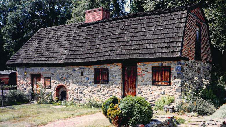 Caleb Pusey House in Upland, with a yard leading up to the building with stone walls and a black shingle roof