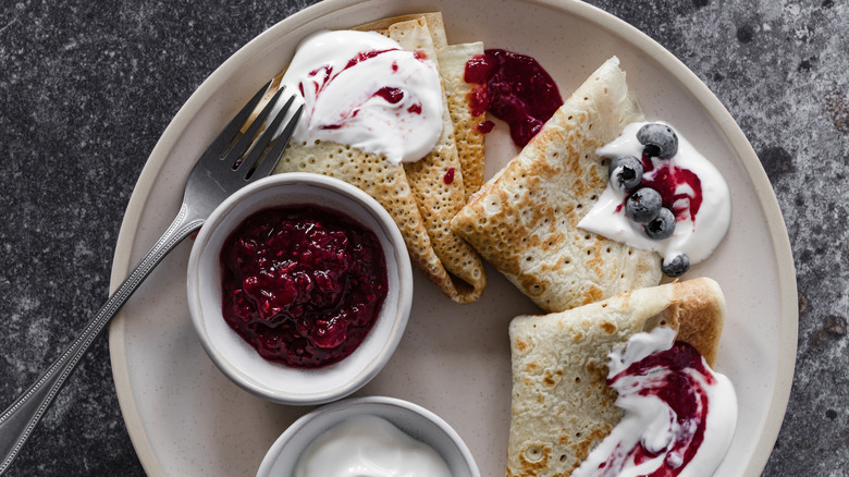 Crêpes with jam on breakfast plate from above