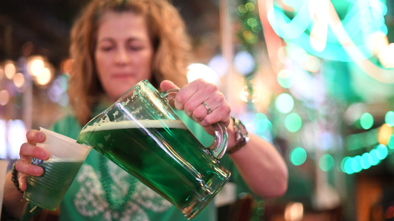 A woman pours a cup of green beer at McGillin's Olde Ale House in Philadelphia on St. Patrick's Day