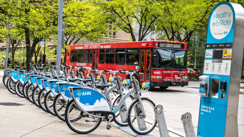 Bicycles stand in a row next to a port authority bus in Oakland, Pittsburgh