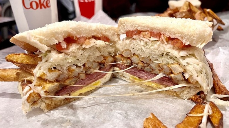 Primanti Bros. sandwich cut in half with an egg, capicola, cheese, french fries, and other toppings