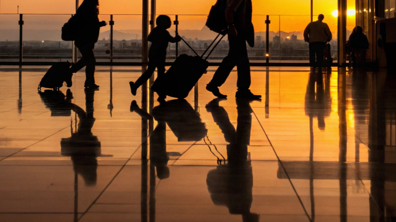 People walking through a modern airport at sunset