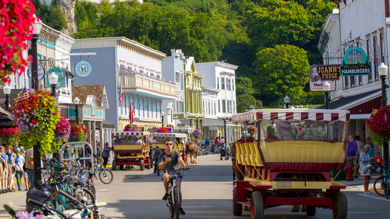 People traveling around Mackinac Island on horse drawn buggies and bicycles