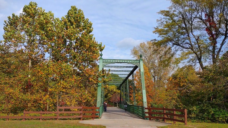 A green truss bridge on the White Lick Creek Bike Trail in Plainfield, Indiana
