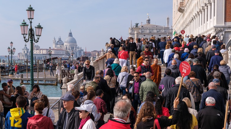 A swarm of tourists crowding a bridge in Venice, Italy.