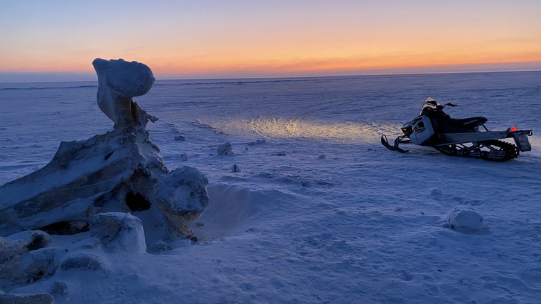 Snowmobile with sunset on the snowy expanse of Point Barrow, Alaska