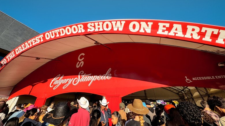 Signage at Calgary Stampede with people in cowboy hats