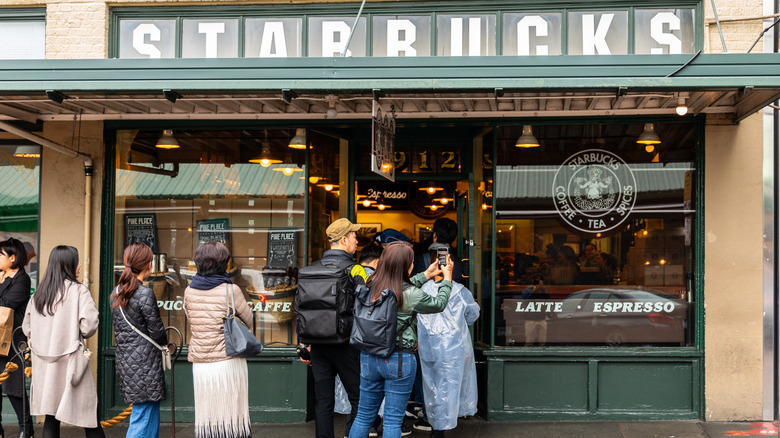 A long line of people waiting outside to enter the original Starbucks in Seattle.