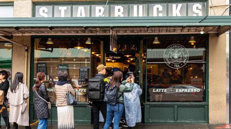 A long line of people waiting outside to enter the original Starbucks in Seattle.