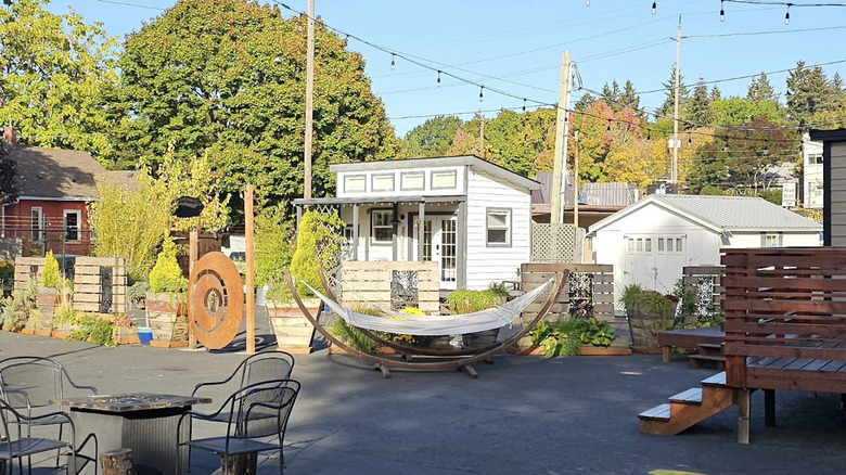 Tiny homes at Tiny Digs and patio with chairs on summer day.