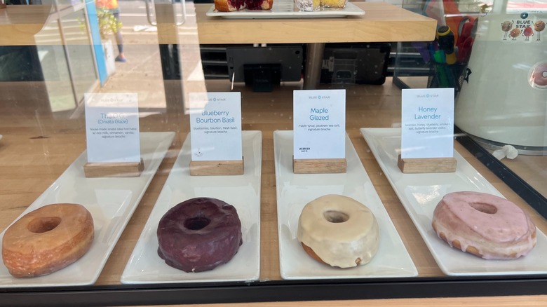 Donuts on display behind a glass at Blue Star Donuts