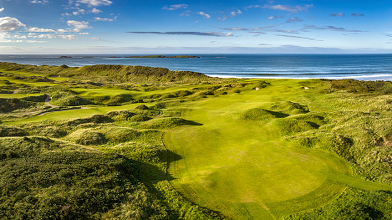 Drone shot of the green at Royal Portrush Golf Club on the cliffs overlooking the sea