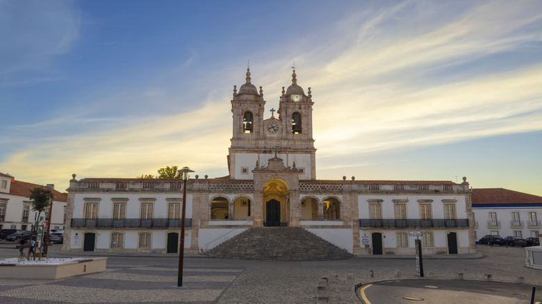 Historic church with twin bell towers under sunset sky in Nazaré
