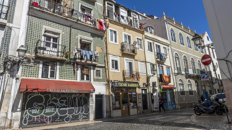 Stores and cafes sit beneath apartments on a cobblestone street in Anjos.