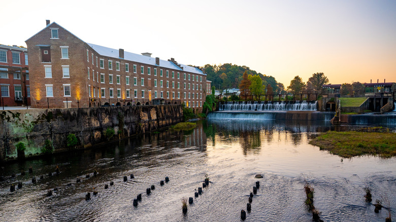 Red brick cotton gin factory next to flowing dam and creek at sunrise Prattville Alabama