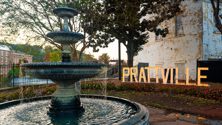 Flowing fountain in front of lit up Prattville sign and old building
