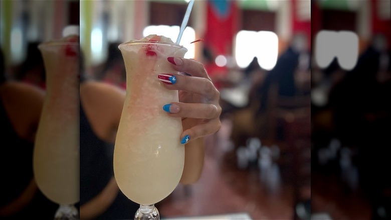Woman holding Pina Colada at El Jibarito restaurant