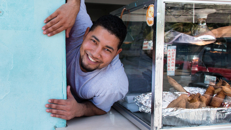 A food truck worker smiles