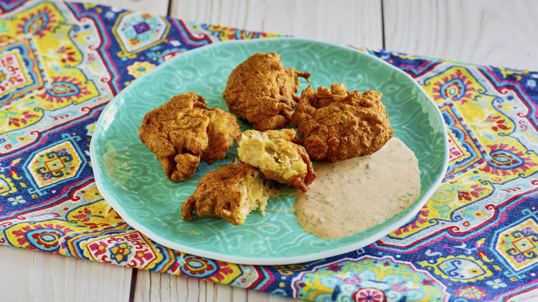 crispy fried conch fritters on a blue plate