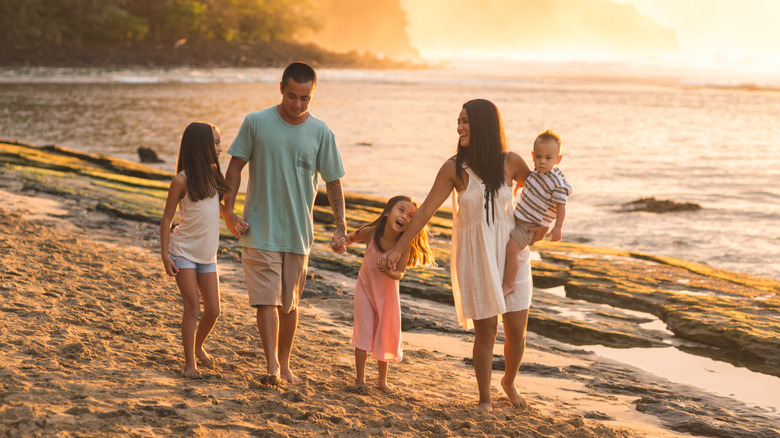 Family walking together at sunset on Hawaiian beach