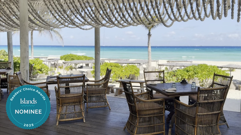 Restaurant seating overlooking a beach at Palmaïa - The House of AïA