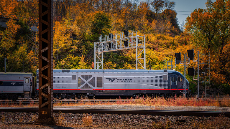 An Amtrak train in Kansas City, surrounded by fall foliage