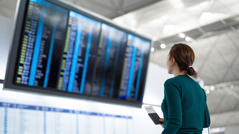 Woman looking at arrival and departure sign