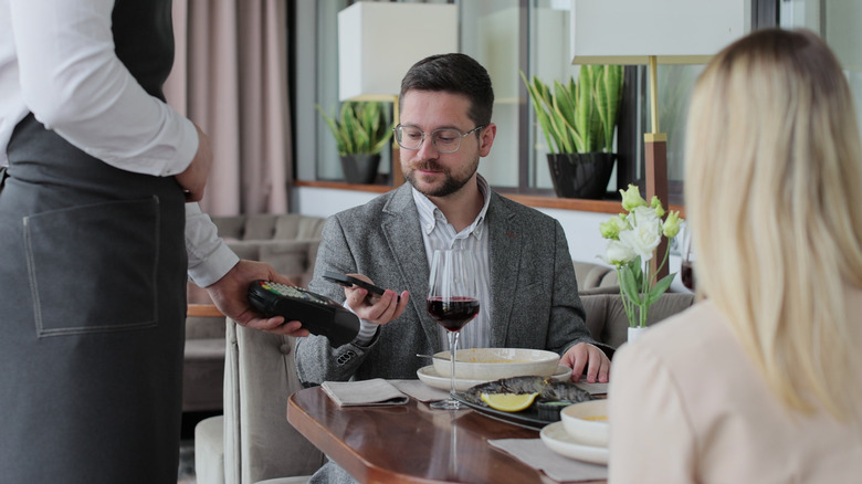 Diners paying the bill inside a restaurant