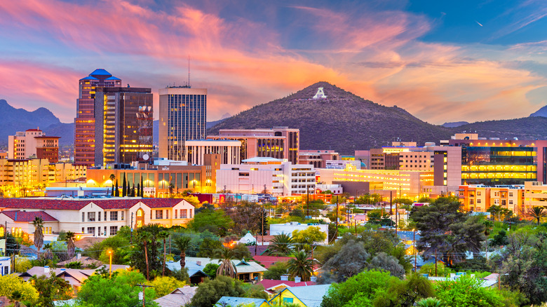 the skyline of downtown Tucson with a mountain in the background at sunset