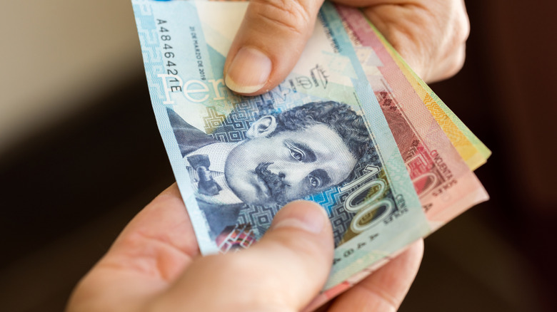 People exchanging colorful Peruvian cash