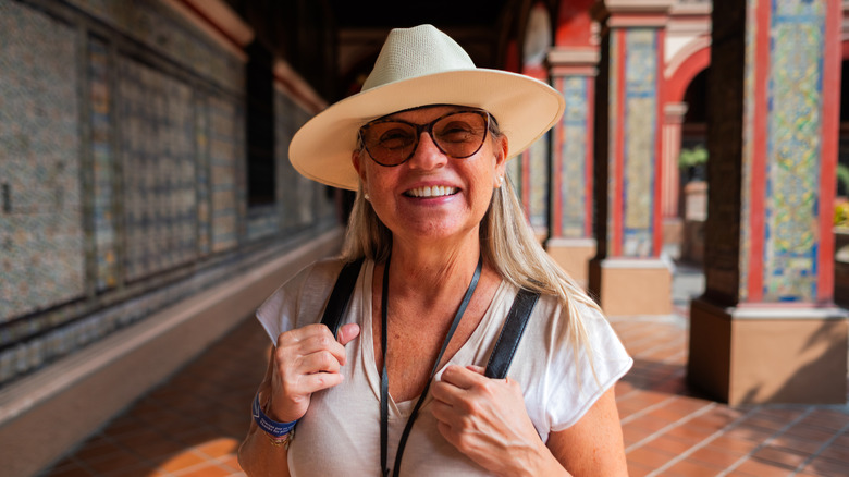 A silver-haired woman smiles on an outdoor walkway in Peru