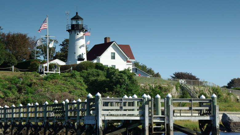 White lighthouse next to a building on a green hill in Warwick, Rhode Island