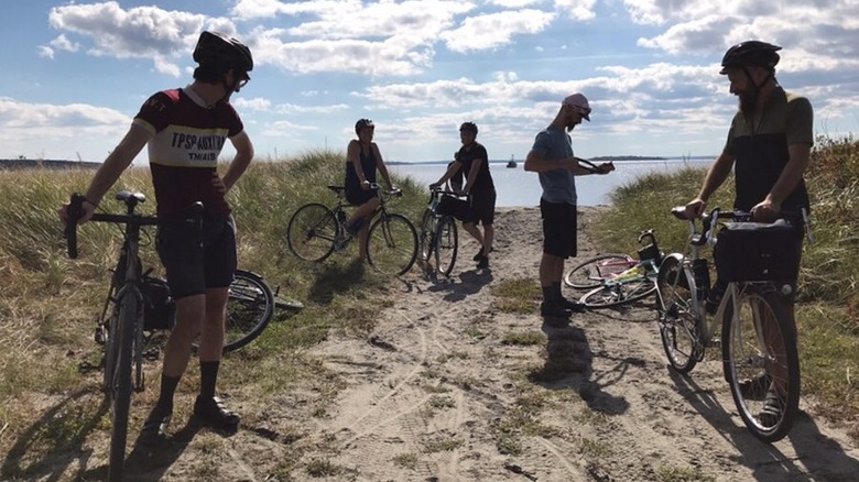 Five cyclists prepare to ride near the beach at Prudence Island