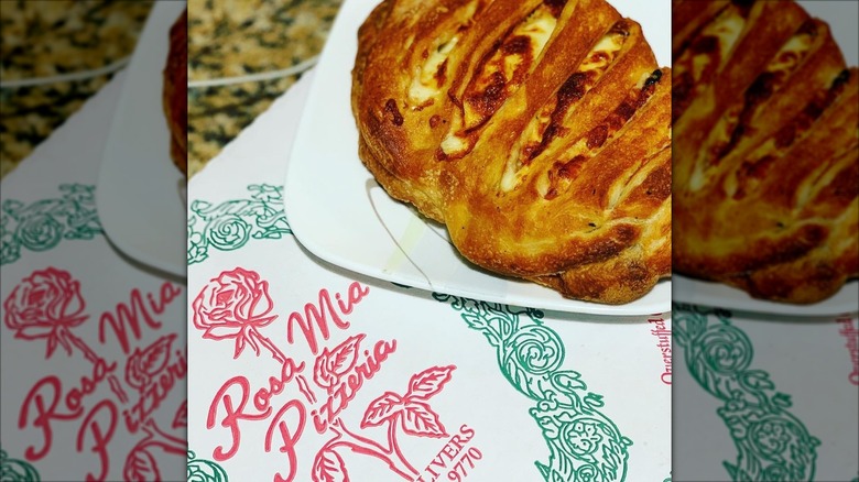 Calzone on top of a plate on a box from Rosa Mia Pizzeria in Johnston, Rhode Island