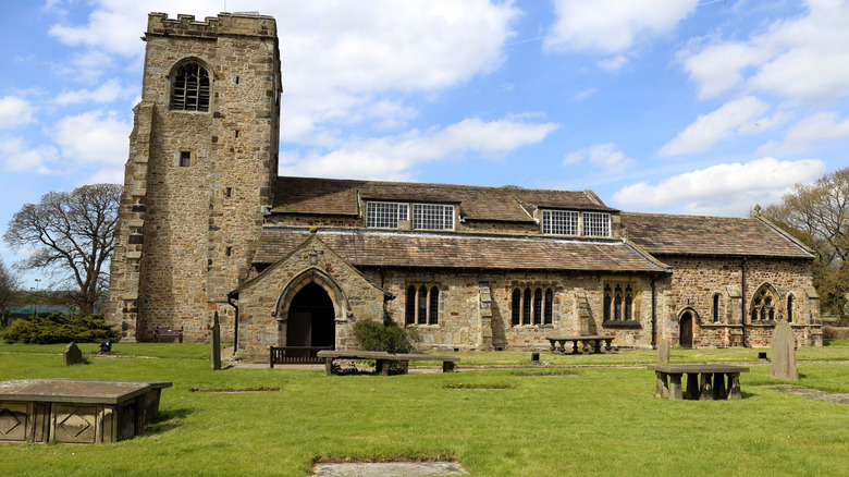 View of St Wilfrid's Church and its immediate surroundings under a partly cloudy sky in Ribchester, England