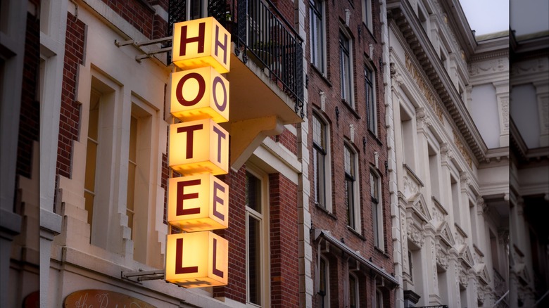 illuminated hotel sign outside brick buildings
