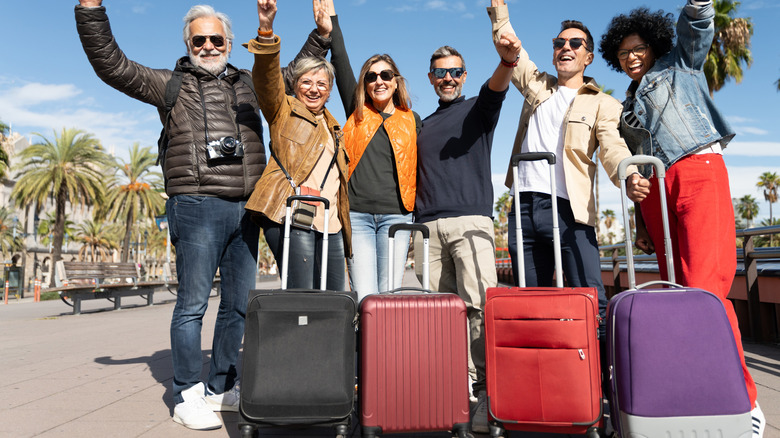 tourist group with suitcases excited to travel
