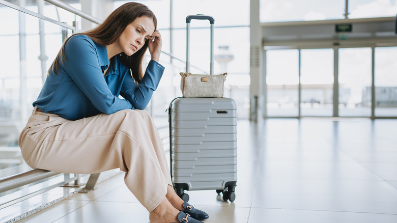 Upset person with their suitcase at the airport