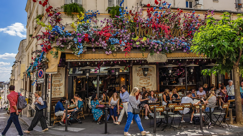 People enjoying drinks and food in Montmartre quarter in Paris, France