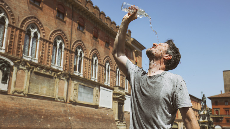 Tourist pouring water on his head because of the heat in Italy