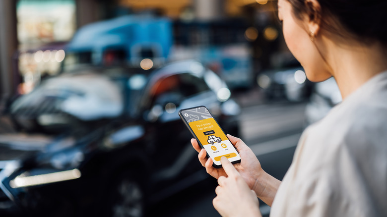 Woman ordering a car through a taxi service app