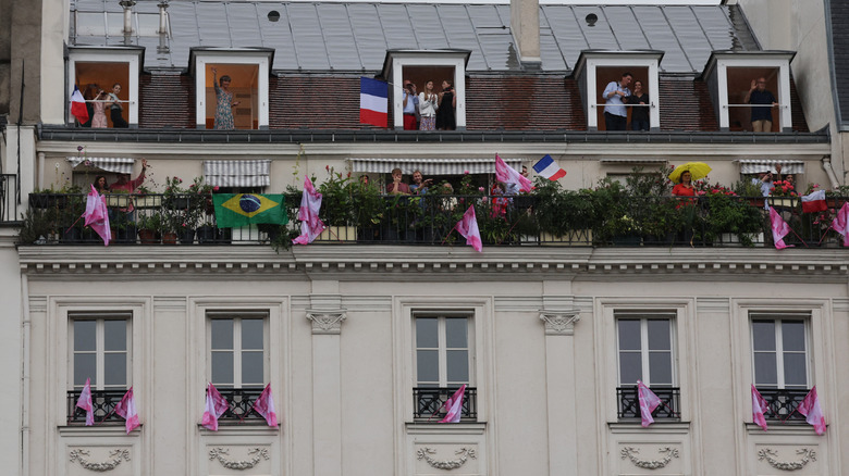 People celebrating sporting event in Paris apartment windows