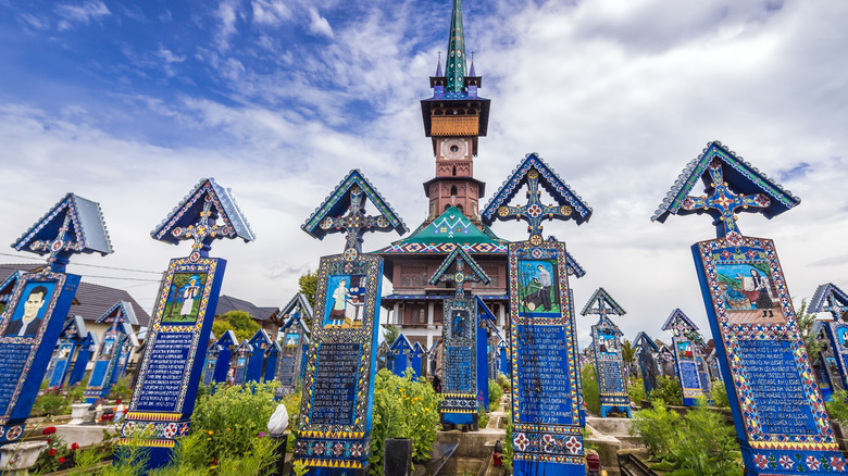 Wooden painted crosses and church in Merry Cemetery, Romania