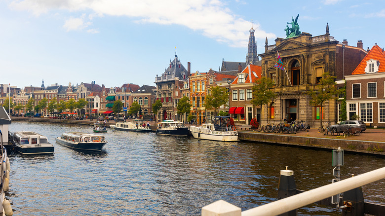 Historic buildings line a canal with houseboats in the town of Haarlem, the Netherlands