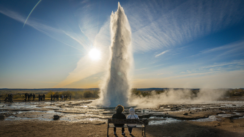 Travelers watching the Icelandic geyser in front of them
