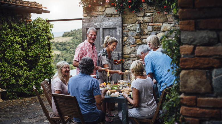 People dining outside an Italian countryside villa
