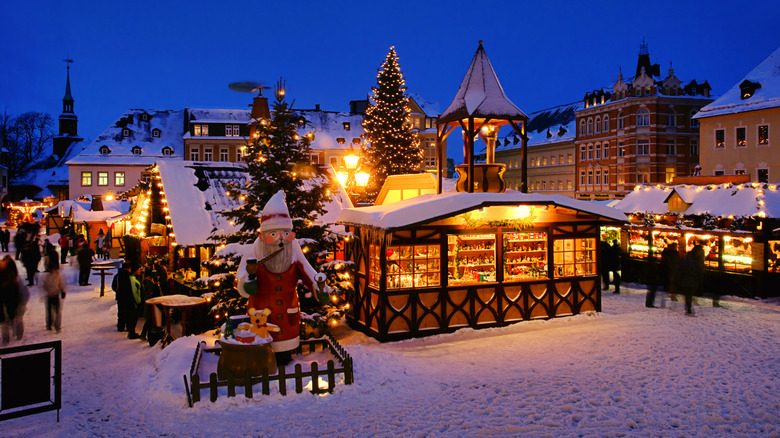 Brightly lit Christmas market in Germany blanketed in snow