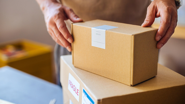 Close up of man's hands handling two packages.