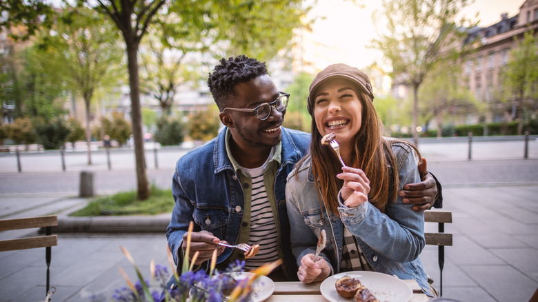 Couple eating at an outdoors table in Europe